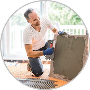 Man laying tile in house