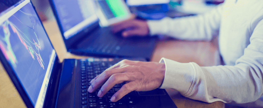 Image of user typing on laptop in blue lighting