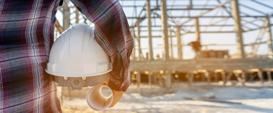Construction worker standing in front of home construction
