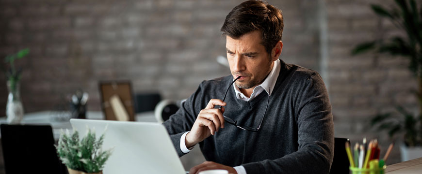 Guy Looking at Computer in Confusion