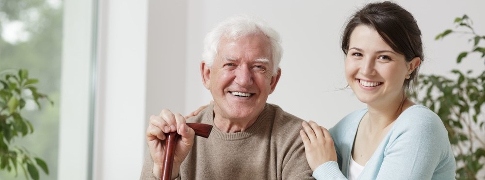 Caring for a Parent, Smiling Daughter seated with Father who has cane in hand