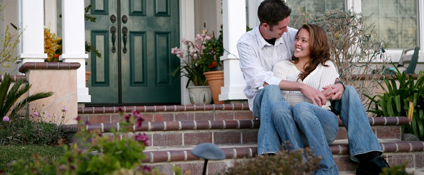 Home Ownership, Young couple sitting on steps of new home