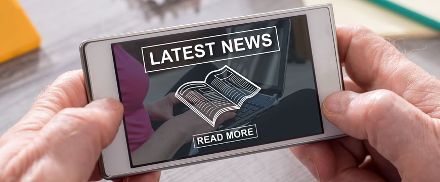 Hands Holding Phone That is Displaying "Latest News" 