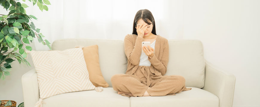 Girl on a Couch Looking at her Phone in Disbelief