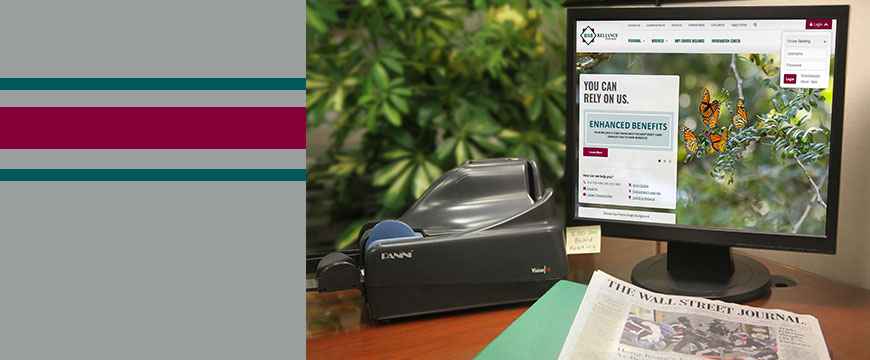 EZeDeposit, Check scanner by a computer screen showing Reliance State Bank's homepage