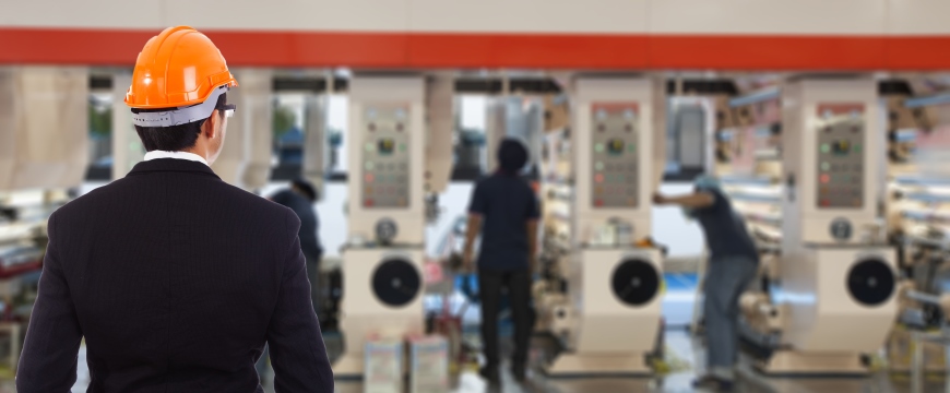 Loan Services - image of manufacturing plant, machines and man in hard hat