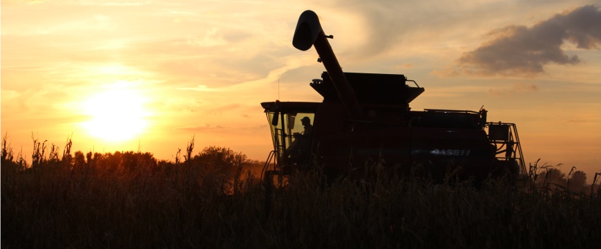 Agricultural Loans, combining corn with a fall harvest sunset